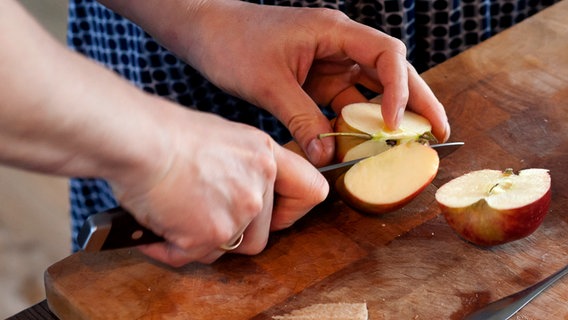 Matthias Gfrörer schneidet einen Apfel. © NDR Foto: Claudia Timmann