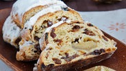 Ein Christstollen mit Marzipan auf einer Holzplatte © Colourbox 