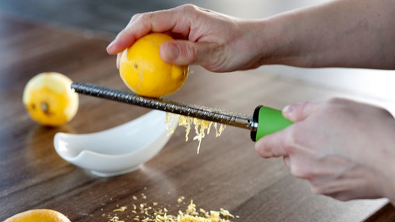 Eine Zitrone wird über eine Reibe gerieben. © NDR Foto: Claudia Timmann
