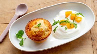 Ein Tassenkuchen auf einem länglichen Teller, daneben Joghurt mit Mango. © NDR Foto: Claudia Timmann