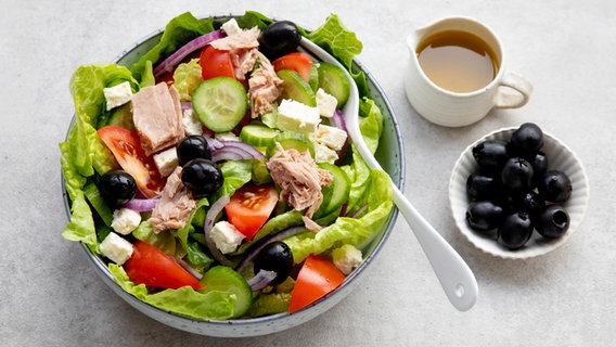 Eine Schüssel mit Thunfisch-Salat, daneben ein Schälchen schwarze Oliven. © NDR Foto: Claudia Timmann