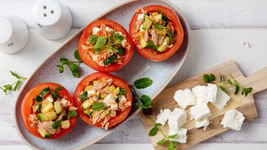 Gefüllte Tomaten auf einem Teller, daneben eine Schale mit Feta. © NDR Foto: Claudia Timmann