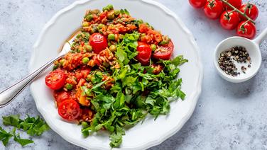 Ein Teller mit Tomatenreis, garniert mit frischer Petersilie. © NDR Foto: Claudia Timmann