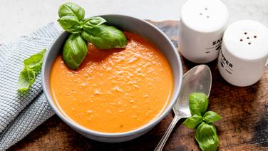 A plate of tomato soup decorated with basil.  © NDR Photo: Claudia Thimmann