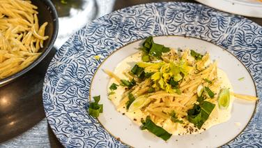 A trophy served on a plate with cheese-cream sauce and herbs.  © NDR Photo: Florian Kruck