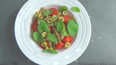Hülsenfrüchte-Pasta mit Avocadocreme, garniert mit Basilikumblättern  