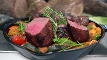 The venison medallions on the vegetable bed are placed in a pan.  © NDR 