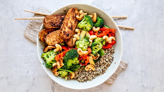 Eine Wok-Pfanne mit Gemüsem gebratenem Tempeh und Quinoa. © NDR Foto: Claudia Timmann