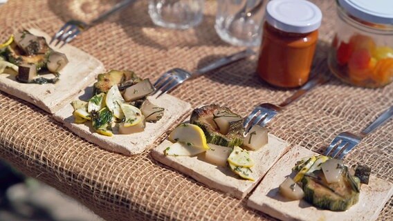 Dreierlei Zucchini auf kleinen Keramikplatten serviert. © NDR/doclights Foto: Marc Vorwerk