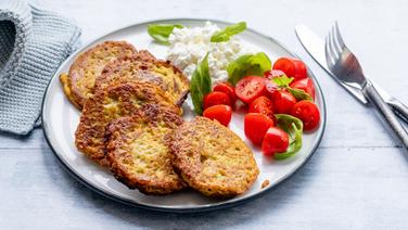 Ein Teller mit Zucchinipuffer, Tomaten und Frischkäse. © NDR Foto: Claudia Timmann