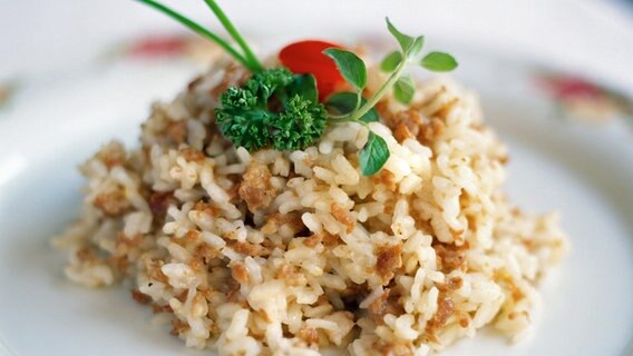 Teller mit einem Reisgericht. © dpa/picture-alliance/Bildagentur Huber/Dutton Colin 