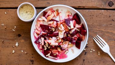 Eine Schüssel Rote-Bete-Salat steht auf dem Tisch, daneben ein Töpfchen Dressing. © NDR Foto: Claudia Timmann