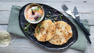 Ein Teller mit zwei Walnuss-Sellerie-Schnitzel und einem Schälchen Möhren-Frischkäse steht auf dem Tisch. © NDR Foto: Claudia Timmann
