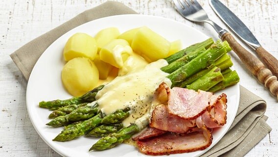 Green asparagus served on a plate with hollandaise, potatoes and ham. Green asparagus served on a plate with hollandaise, potatoes and ham. © colourbox photo: -