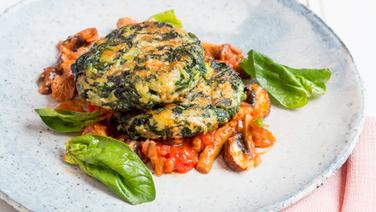 Two spinach patties on a tomato and mushroom sauce are on a plate.  © NDR Photo: Claudia Timmann