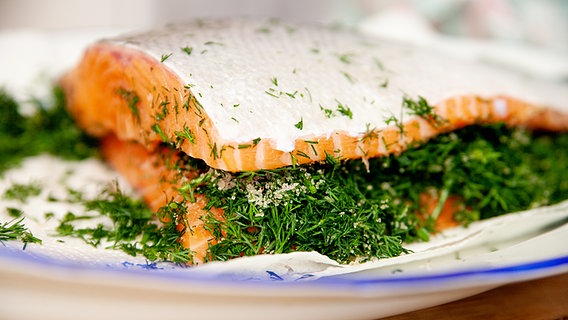 Eine Platte mit Lachs, der zum Beizen mit vielen Kräutern belegt ist. © NDR Foto: Claudia Timmann