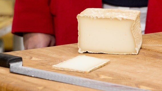 Ein Stück Käse der Sorte Brique Brebis Roncevaux auf einem Holzbrett © NDR Foto: Claudia Timmann