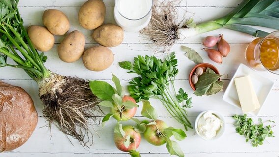 Zutaten für eine Kartoffelsuppe liegen auf einem Holzbrett. © NDR Foto: Claudia Timmann