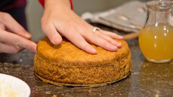 Eine Torte wird in verschiedene Böden geschnitten. © NDR Foto: Claudia Timmann