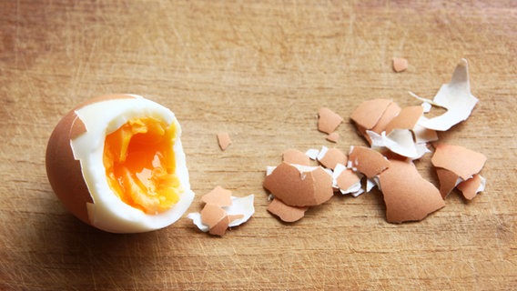 Ein gepelltes, gekochtes Ei liegt auf einer Holzfläche. © photocase.de Foto: cyooh