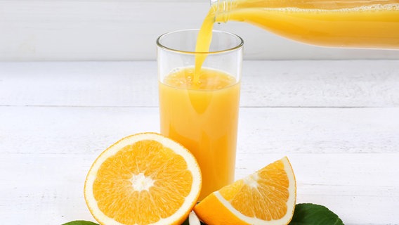 Orangensaft wird in ein Glas gegossen © imago images / Shotshop 