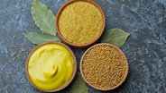 Gelbe ganze Senfkörner, gemahlene Senfkörner und fertiger, feiner Senf - je in einer Schale. © Colourbox Foto: AtlasStudio