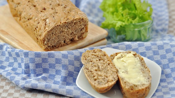 A small slice of wholemeal bread with butter on a plate.  © fotolia Photo: A_Lein
