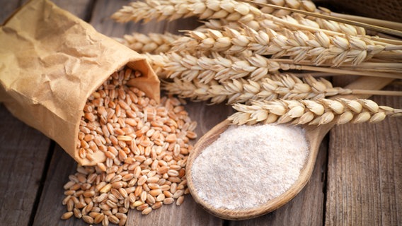 Wheat ears, grains and flour on a wooden table.  © fotolia Photo: Christian Jung