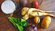 Wintergemüse auf einem Holztisch, unter anderem Kartoffeln, Rettich, Rote Bete und Feldsalat. © Fotolia.com Foto: Sinuswelle