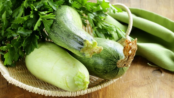 Frische Zucchini liegen in einem flachen Korb. © Colourbox 
