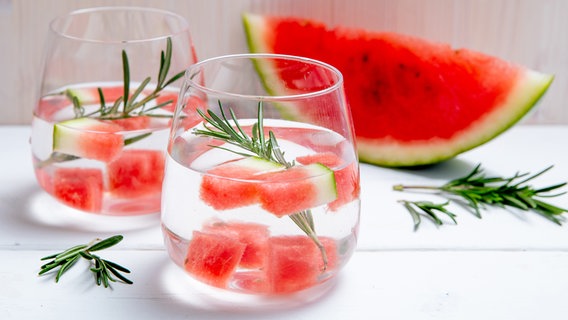 Zwei Gläser Wasser mit Melonenstückchen und Rosmarin stehen auf einem Tisch. © NDR Foto: Claudia Timmann