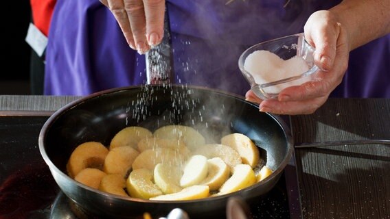 Apfelspalten werden in einer Pfanne mit Zucker karamellisiert © NDR Foto: Claudia Timmann