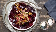 Ein Teller mit Rote-Bete-Salat mit Schalotten und Walnüssen auf einem orientalischen Tablett © NDR Foto: Claudia Timmann