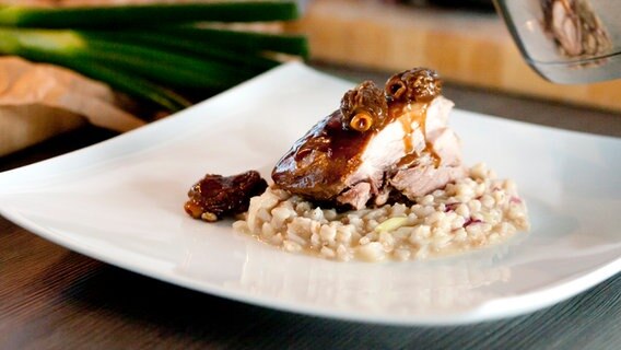 Ein Stück Putenkeule und Graupen-Risotto auf einem Teller © NDR Foto: Claudia Timmann