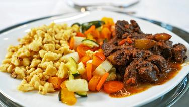 Wild boar goulash with spaetzle and oven-roasted vegetables served on a plate.  © NDR/megaherz GmbH 