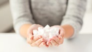 Eine Frau hält Zuckerwürfel in den Händen. © fotolia.com Foto: Syda Productions