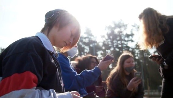 Eine Schülerin der Waldschule Hatten guckt auf ihr Handy. © NDR 