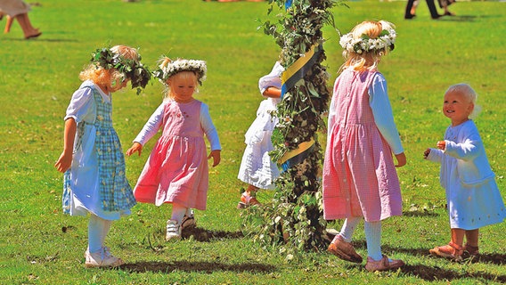 Kinder mit Blumenkränzen tanzen um eine geschmückte Stange zum Mittsoimmerfest.  Schweden um einen © picture-alliance / HB- Verlag Foto: Michael Riehle