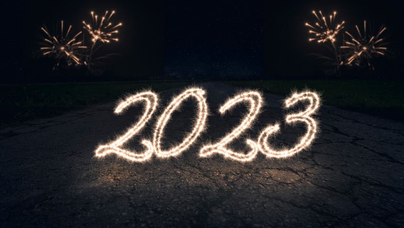 Die Jahreszahl 2023 - geschrieben mit Wunderkerzen - leuchtet auf einer dunklen Straße. © picture alliance / CHROMORANGE Foto: Michael Bihlmayer