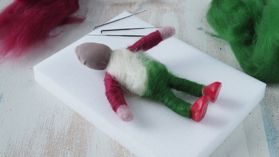 Eine Puppenfigur aus Schafwolle liegt auf einer Schaumstoffunterlage. © NDR Foto: Anja Deuble