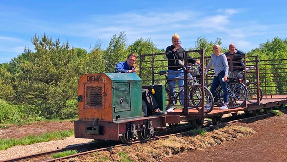 Besucher mit Fahrrädern auf der alten Torfbahn im Himmelmoor. © NDR Foto: Sabine Klein