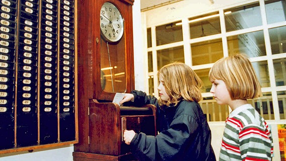 Zwei Kinder probieren im Industriemuseum Elmshorn eine Stechuhr aus. © Industriemuseum Elmshorn 