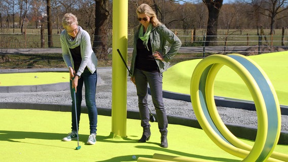 Besucherinnen des Stadtparks Norderstedt spielen Minigolf. © Stadtpark Norderstedt 
