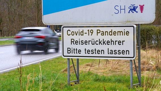 Ein Warnschild an der deutsch-dänischen Grenze weist Reiserückkehrer auf Testpflich hin. © Picture-Alliance / Jörg Carstensen 