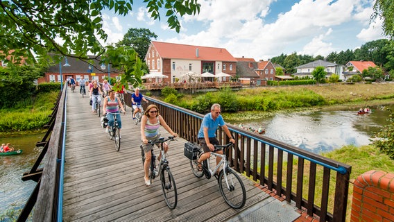 Radfahrer überqueren eine Holzbrücke über die Hase in Herzlake im Emsland. © Hasetal Touristik GmbH 