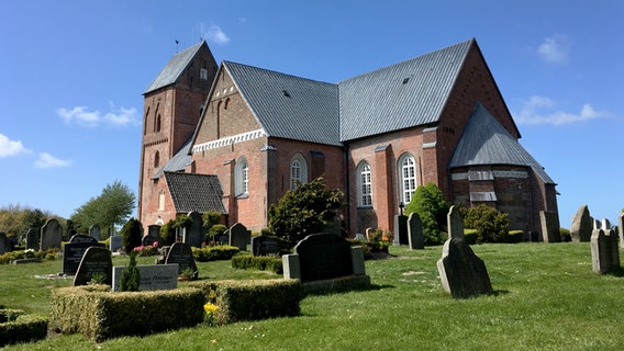 Die mittelalterliche St. Johannis-Kirche und der davor liegende Friedhof in Nieblum auf Föhr. © NDR Foto: Gitte Alpen
