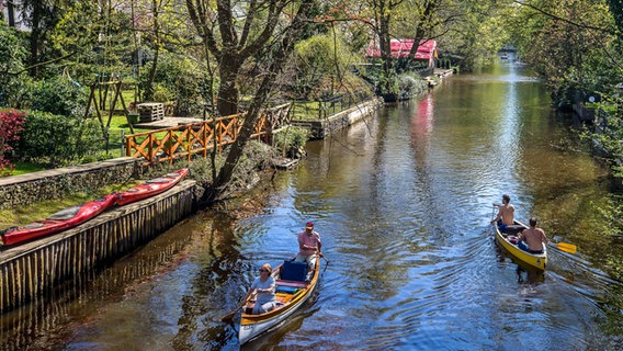 Zwei Kanus fahren bei schönem Wetter auf einem Alsterkanal in Hamburg. © imago images/Hoch Zwei Stock/Angerer 