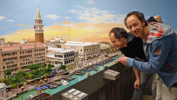 Frederik und Gerrit Braun zeigen auf den neuen Venedig-Abschnitt im Miniatur Wunderland in Hamburg © NDR Foto: Irene Altenmüller