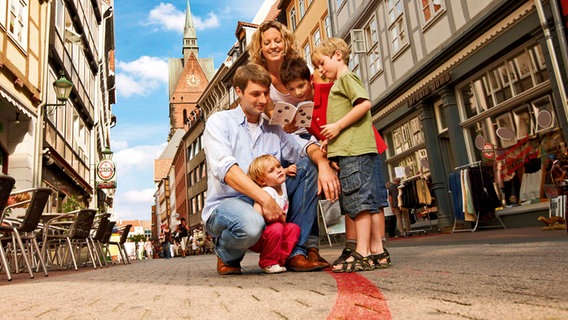 Eine Familie macht in Hannover einen Stadtrundgang entlang des "Roten Fadens". © HMTG 