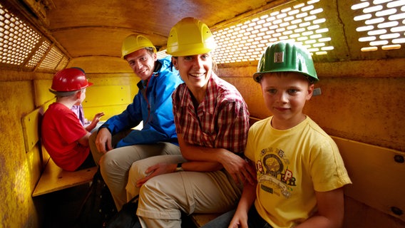 Eine Familie sitzt in einer Grubenbahn im Besucherbergwerk Rammelsberg. © Harzer Tourismusverband Foto: M. Gloger